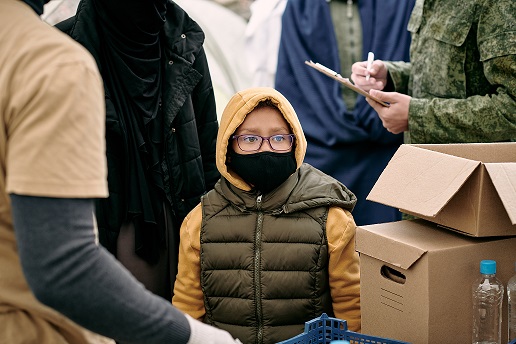 Child in protective mask waiting for spreading free food