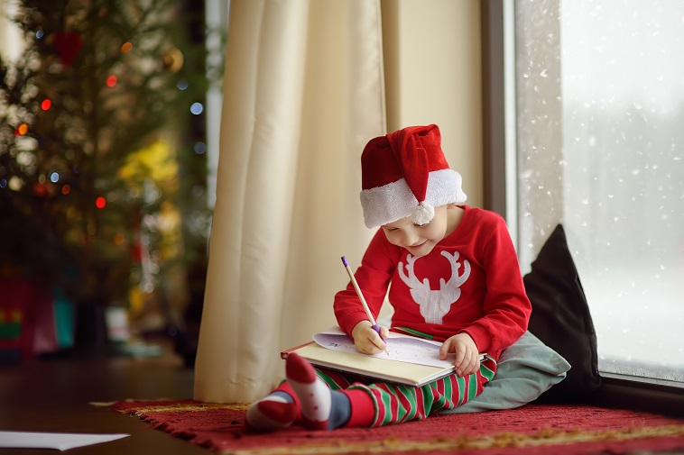 Child sat in front of a Christmas tree