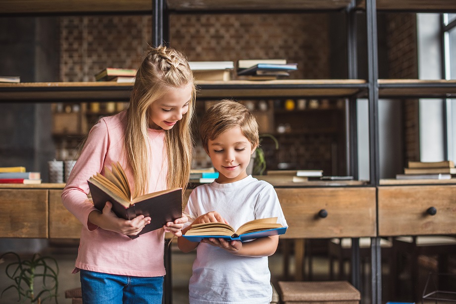 portrait of smiling siblings with books in hands