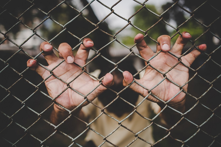 Hand with metal fence, feeling no freedom