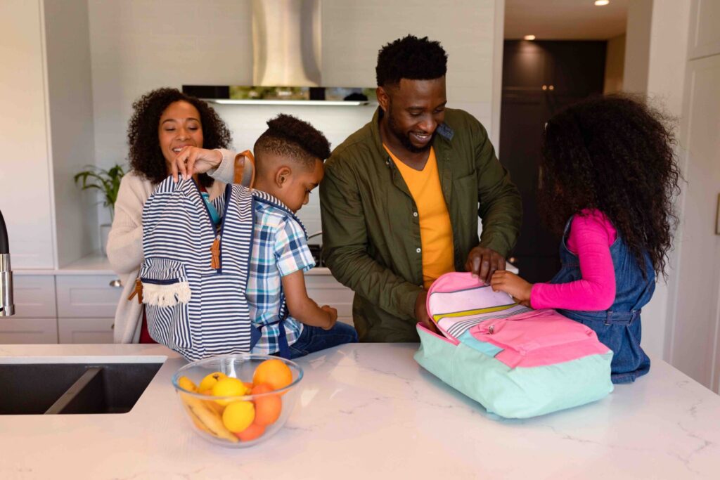 Family packing bags for children to take to school