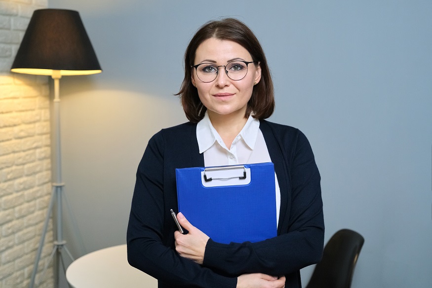 Social worker with clip board looking at camera