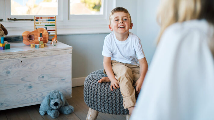 Young child sat on chair in bedroom