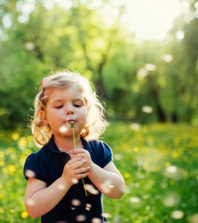 child playing outdoors in the grass in the park