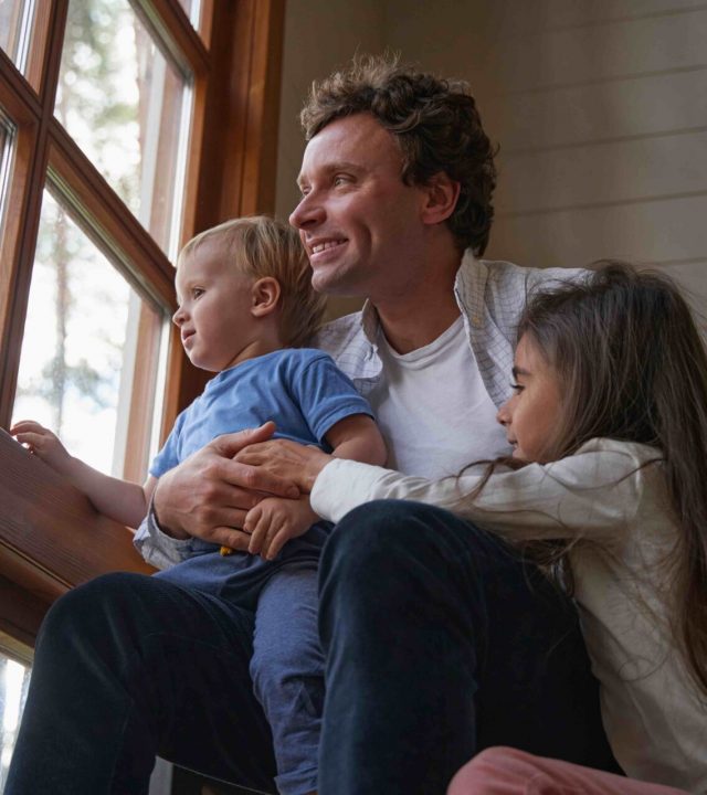 Close up of happy man embracing his children