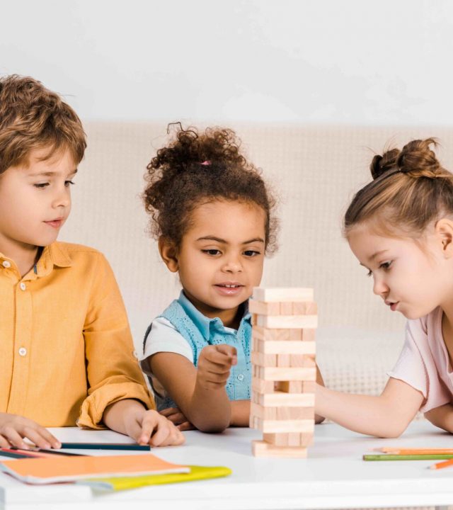 Children playing with wooden blocks on a table