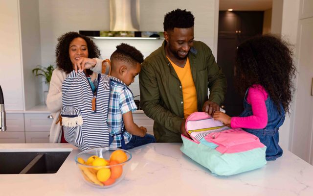 Family packing bags for children to take to school