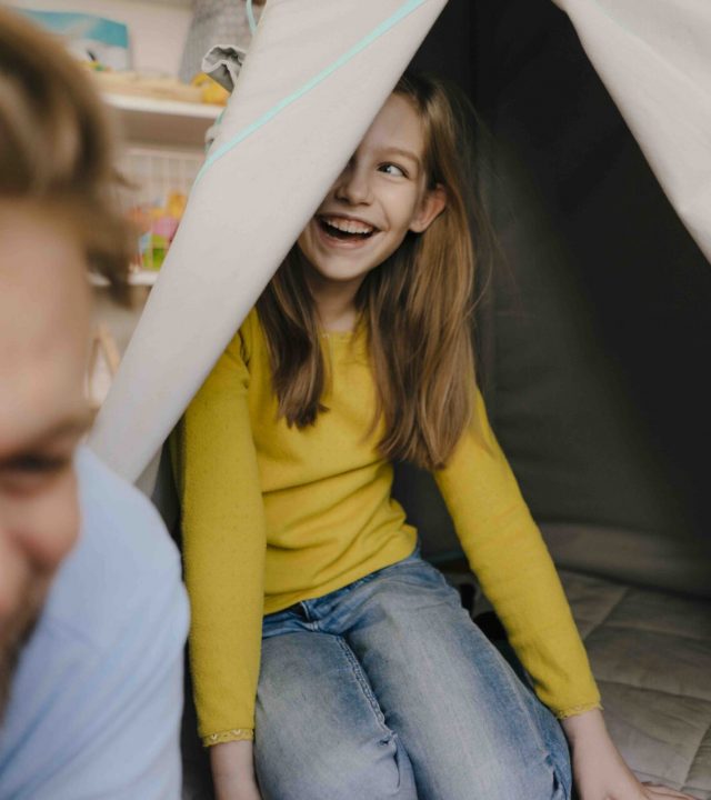 Father and daughter with teepee in children's room